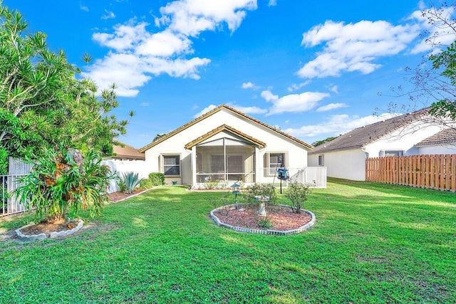 back of property featuring a sunroom and a yard