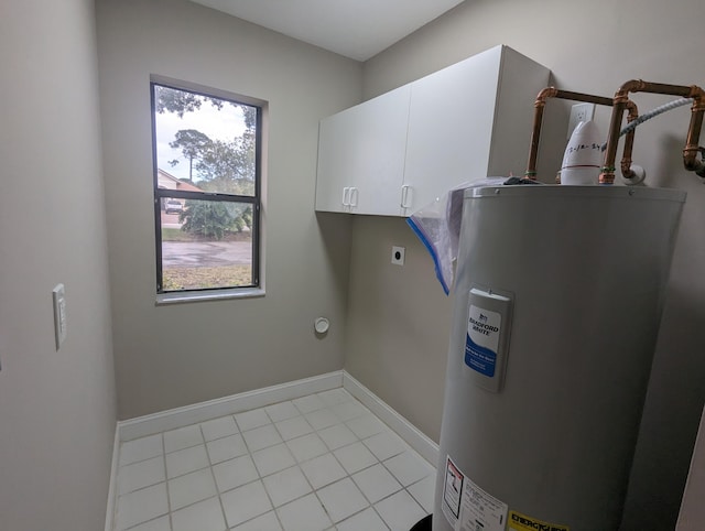 laundry room featuring electric dryer hookup, light tile patterned flooring, cabinets, and water heater