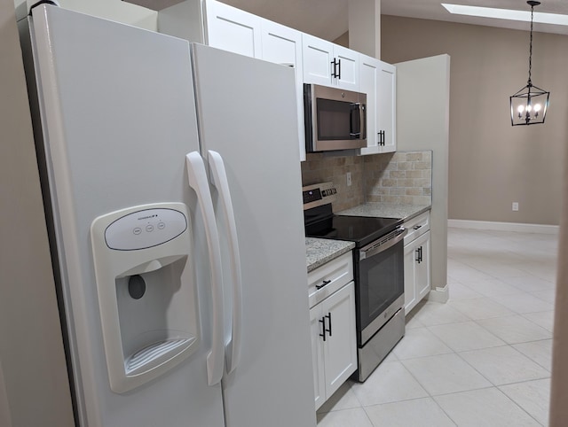 kitchen featuring decorative backsplash, appliances with stainless steel finishes, light stone counters, vaulted ceiling, and white cabinets