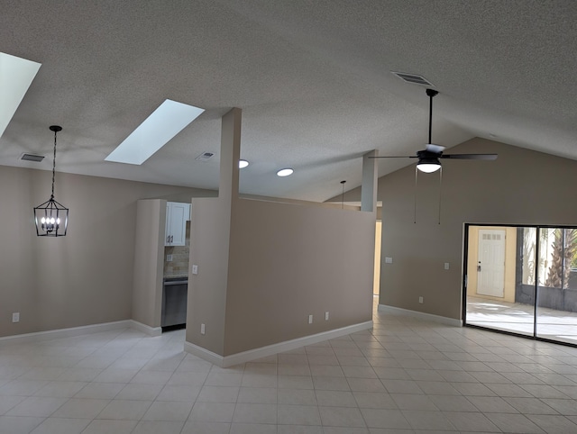 unfurnished living room with ceiling fan, vaulted ceiling with skylight, light tile patterned flooring, and a textured ceiling