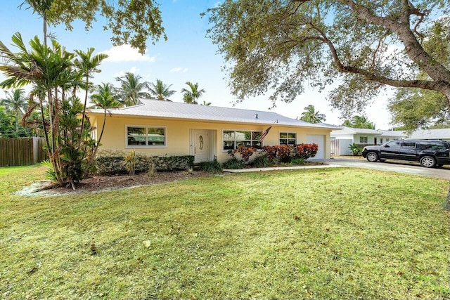 ranch-style house featuring a garage and a front lawn