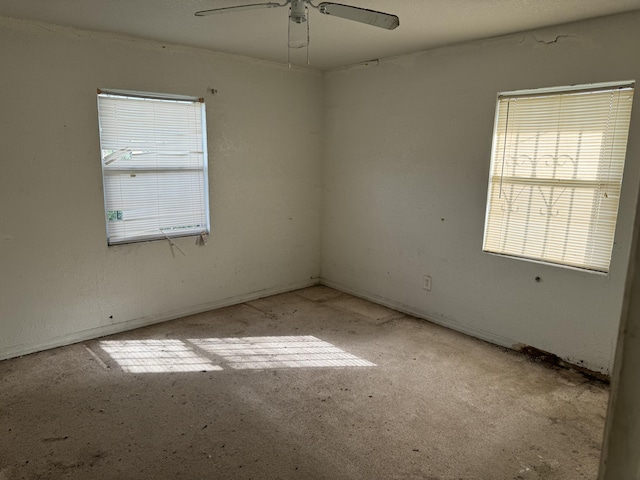 empty room featuring ceiling fan and plenty of natural light