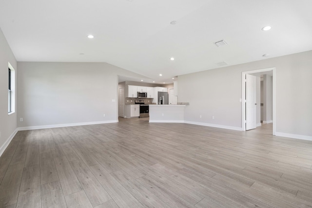 unfurnished living room with baseboards, light wood-style flooring, and recessed lighting