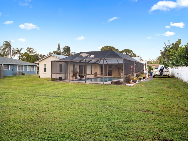 rear view of property with a lanai, central air condition unit, a lawn, and a fenced in pool