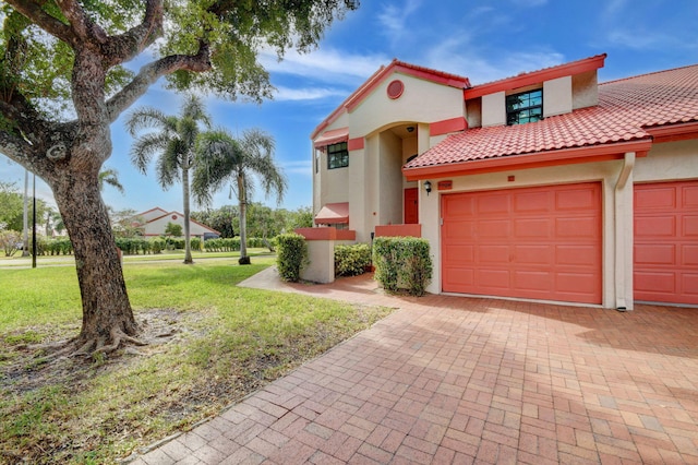 mediterranean / spanish home featuring a front lawn and a garage