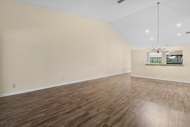 unfurnished living room featuring lofted ceiling, hardwood / wood-style flooring, a textured ceiling, and a chandelier