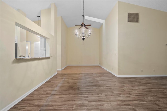 unfurnished dining area with wood-type flooring, high vaulted ceiling, and ceiling fan