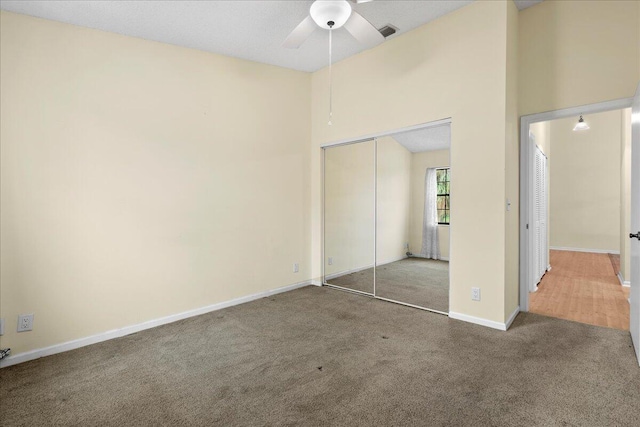 unfurnished bedroom featuring carpet flooring, a closet, and ceiling fan