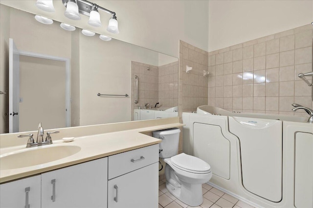 bathroom with toilet, vanity, tile patterned floors, and a tub to relax in