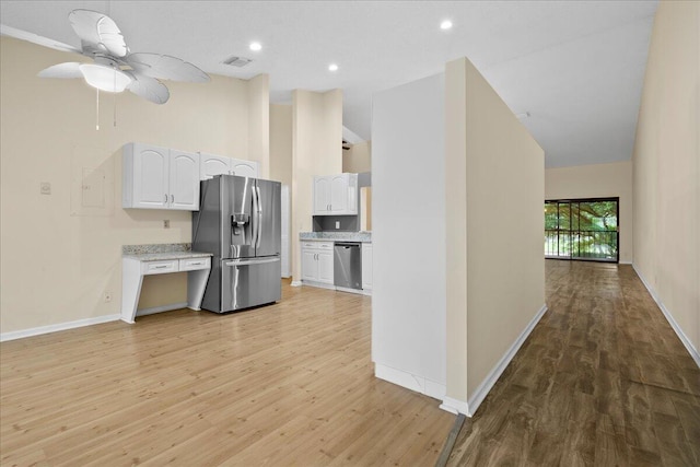 kitchen with light wood-type flooring, appliances with stainless steel finishes, ceiling fan, and white cabinetry