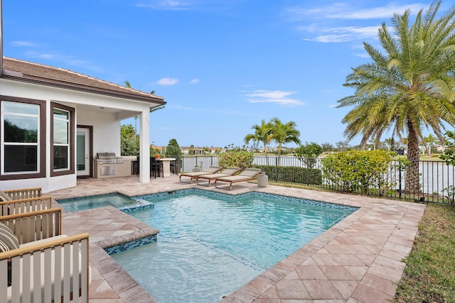 view of pool with a patio, a pool with connected hot tub, area for grilling, and fence