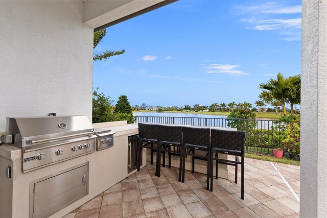 view of patio / terrace featuring grilling area and a water view