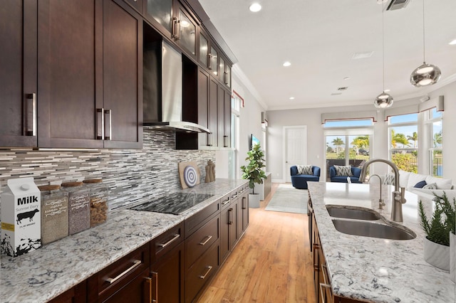 kitchen with sink, wall chimney exhaust hood, light wood-type flooring, black electric cooktop, and ornamental molding