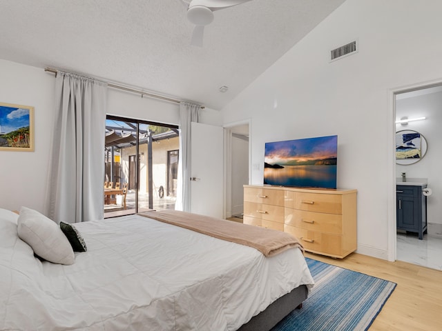 bedroom featuring access to exterior, ensuite bath, a textured ceiling, ceiling fan, and light hardwood / wood-style floors