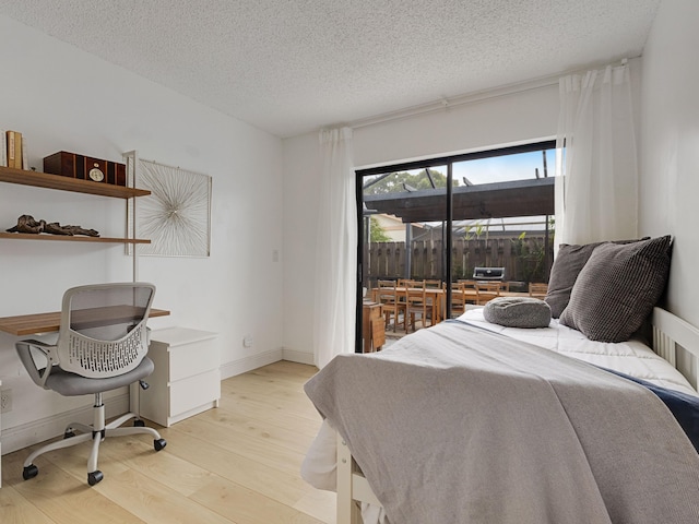 bedroom with a textured ceiling and light hardwood / wood-style flooring