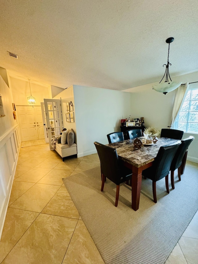 dining room with light tile patterned floors and a textured ceiling