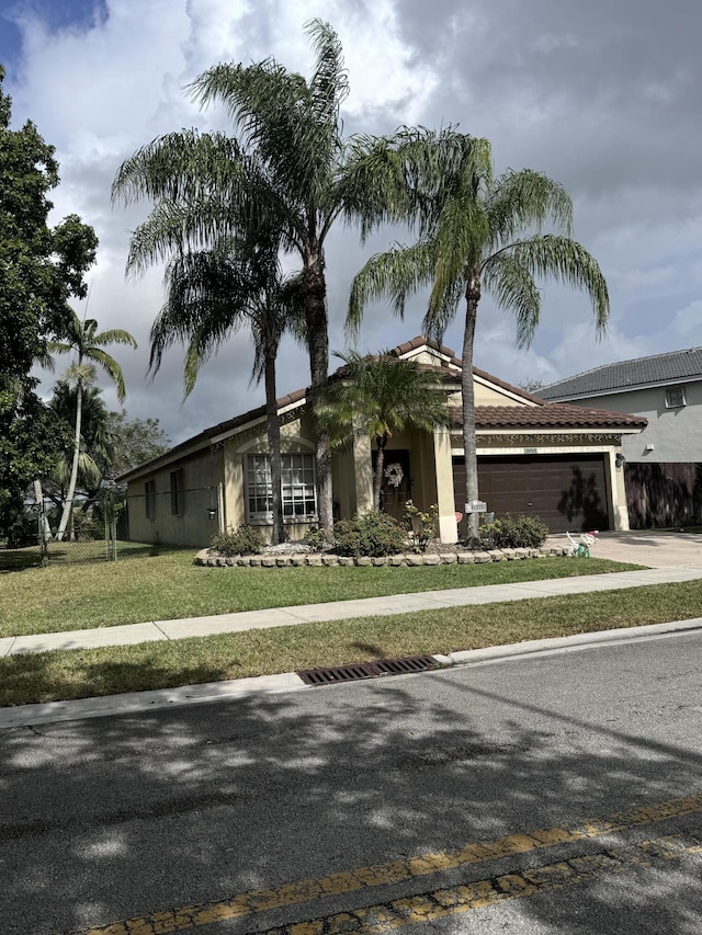 view of front of home featuring a garage and a front lawn