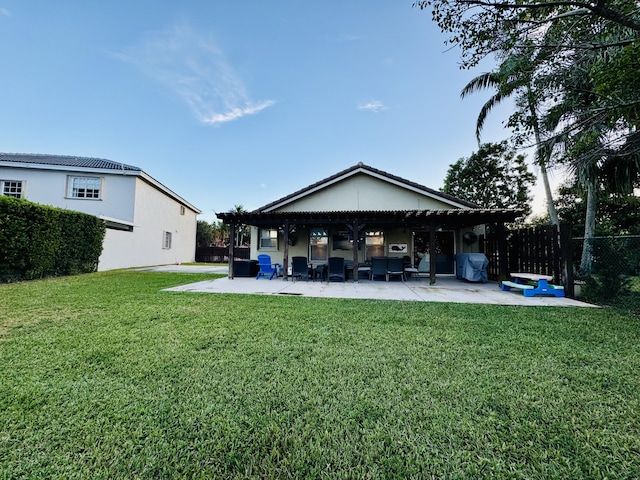 rear view of property featuring a patio, a pergola, and a lawn