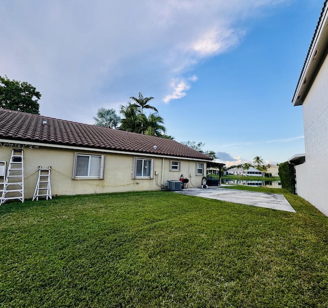 rear view of property with a patio, a yard, and cooling unit