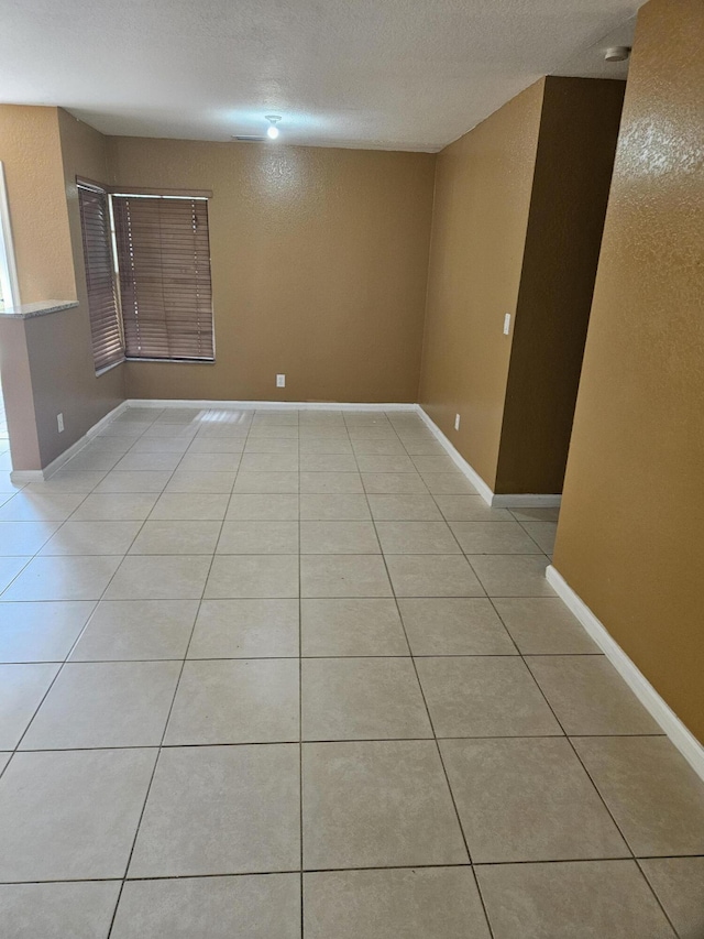 spare room with light tile patterned floors and a textured ceiling