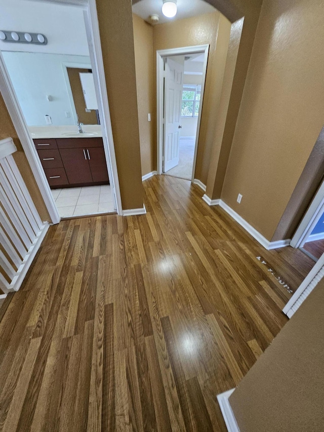 hallway featuring light hardwood / wood-style flooring and sink