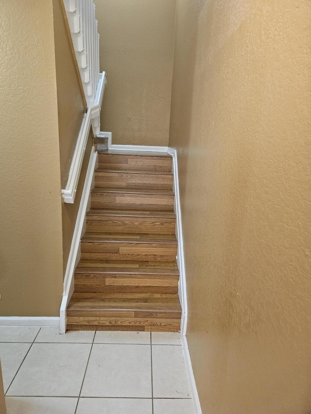 stairway featuring tile patterned flooring