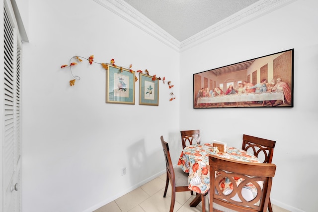 tiled dining area with ornamental molding and a textured ceiling