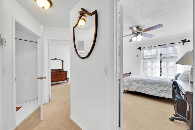 carpeted bedroom featuring a textured ceiling, ceiling fan, and crown molding