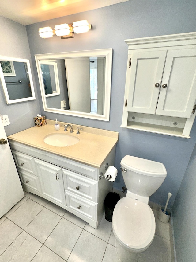 bathroom with tile patterned flooring, vanity, and toilet