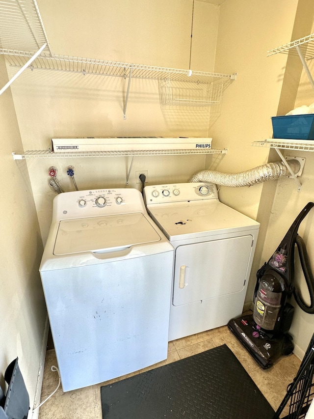 laundry room with washer and clothes dryer and light tile patterned floors