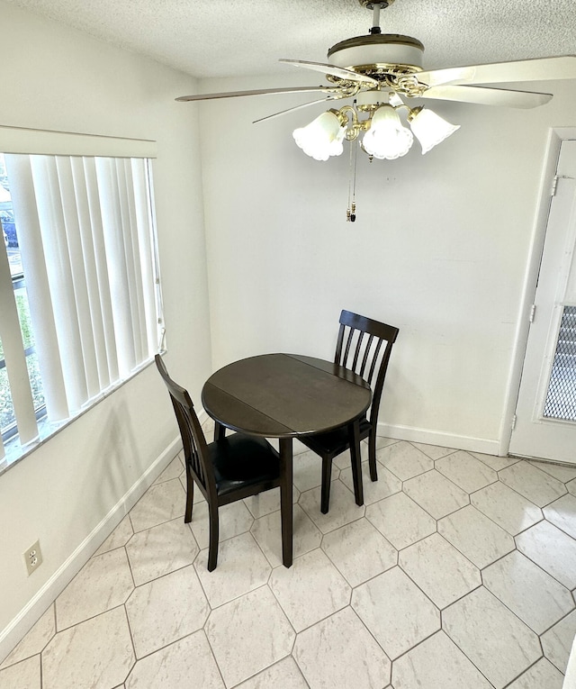 dining room with ceiling fan and a textured ceiling