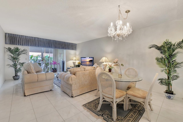 dining area with a chandelier, light tile patterned floors, and a textured ceiling