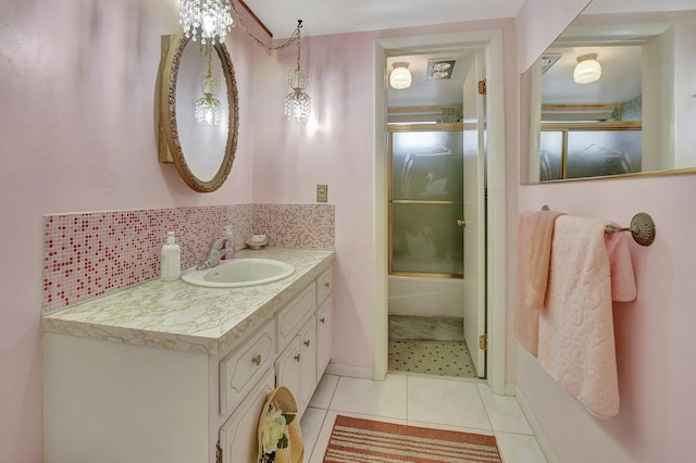 bathroom with tile patterned flooring, decorative backsplash, combined bath / shower with glass door, and vanity