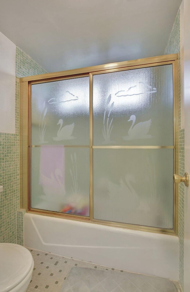 bathroom featuring shower / bath combination with glass door and toilet