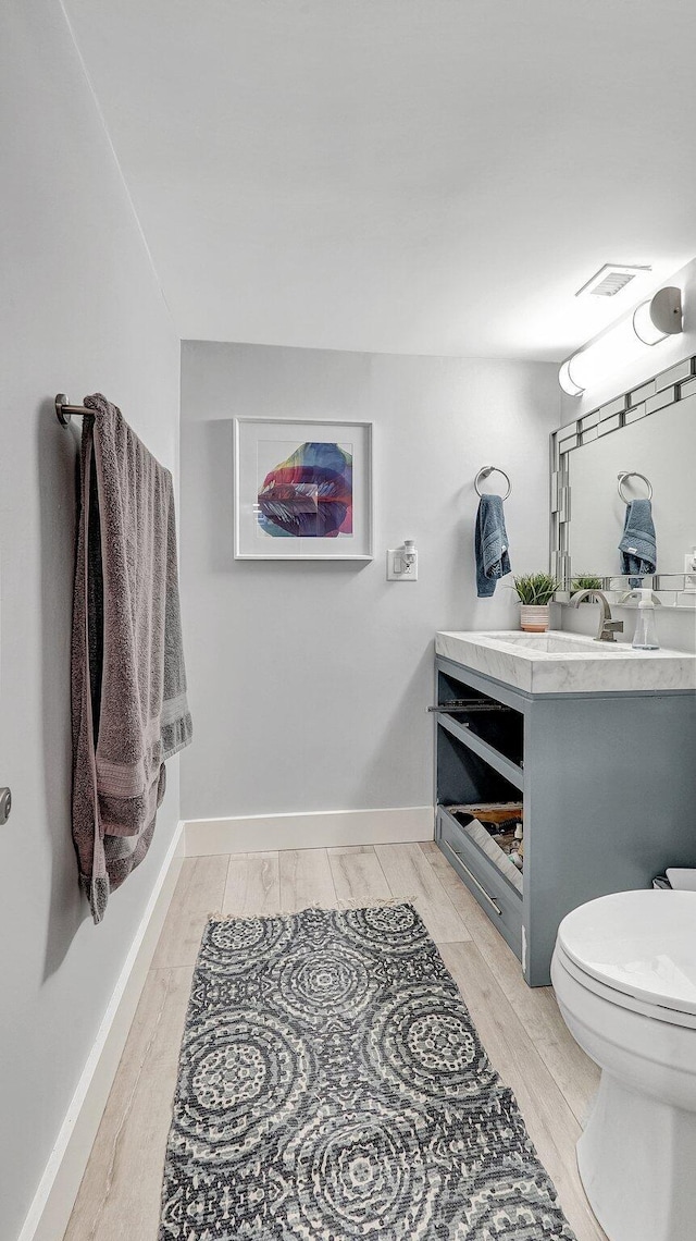 bathroom featuring vanity, hardwood / wood-style flooring, and toilet