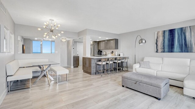 living room featuring light hardwood / wood-style flooring and an inviting chandelier