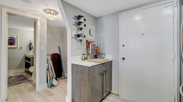 bathroom with toilet, vanity, hardwood / wood-style flooring, and an inviting chandelier