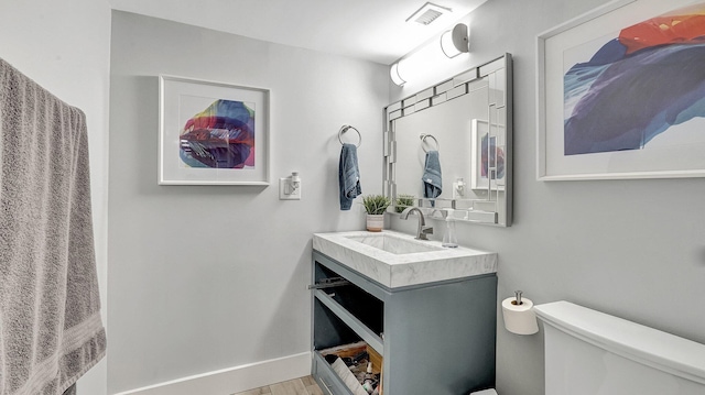 bathroom featuring hardwood / wood-style floors, vanity, and toilet