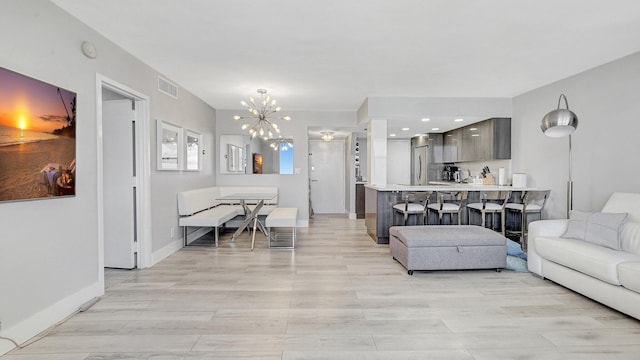 living room featuring light hardwood / wood-style floors and a notable chandelier