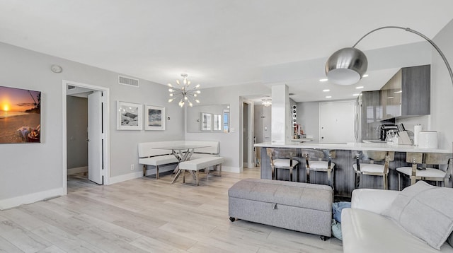 living room with an inviting chandelier and light hardwood / wood-style flooring