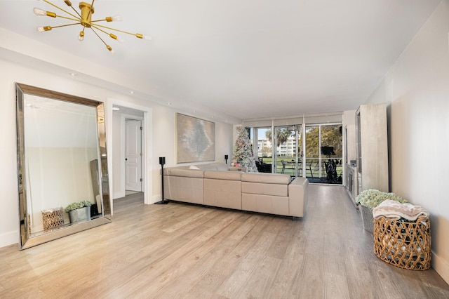 living room featuring a chandelier and light wood-type flooring