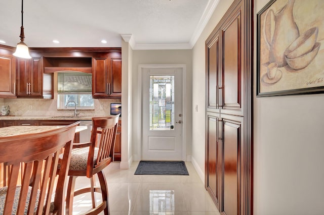 kitchen with tasteful backsplash, sink, pendant lighting, and ornamental molding