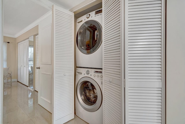 washroom featuring light tile patterned floors, stacked washer and dryer, and ornamental molding