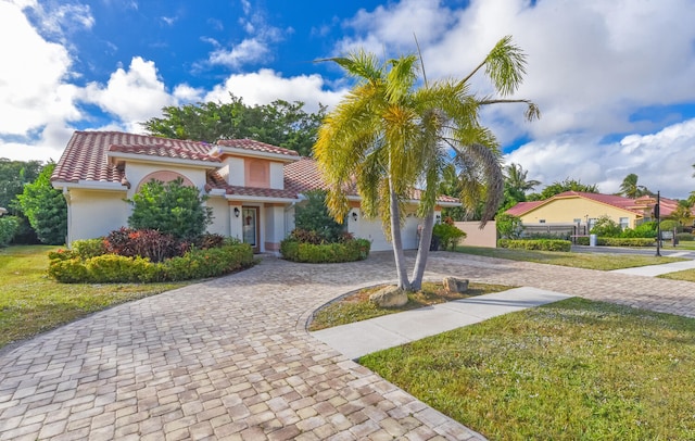 mediterranean / spanish home featuring a garage and a front yard