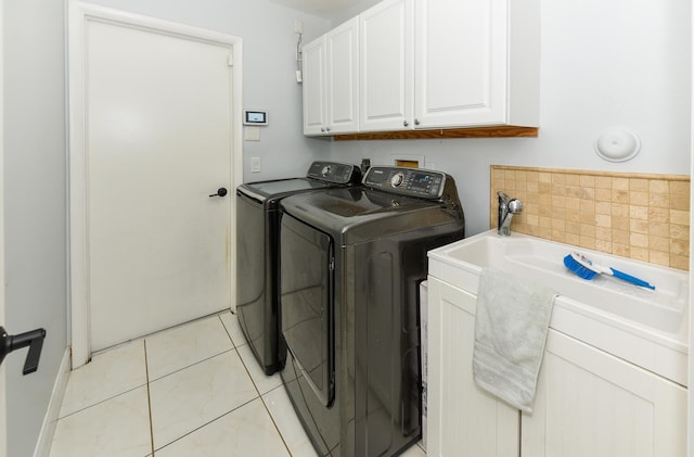 laundry room with cabinets, washing machine and dryer, and light tile patterned flooring