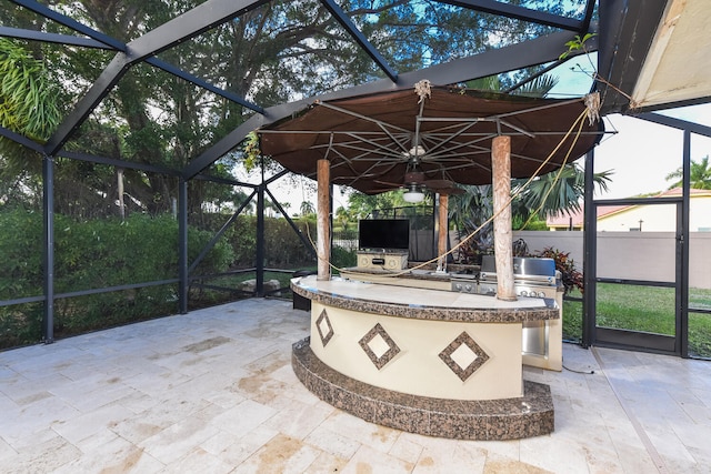 view of patio / terrace with glass enclosure and an outdoor kitchen