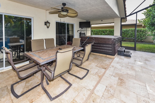 view of patio with a lanai, ceiling fan, and a hot tub