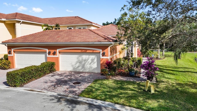 mediterranean / spanish-style home with a garage and a front lawn