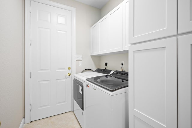 laundry area featuring cabinets, light tile patterned flooring, and washing machine and dryer