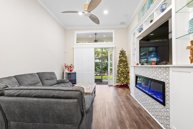 living room with a fireplace, ceiling fan, wood-type flooring, and crown molding